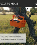 Person carrying the Sixer 16 Protective Case With Removable Tool Tray Blaze Orange in field, showing portability and rugged use.