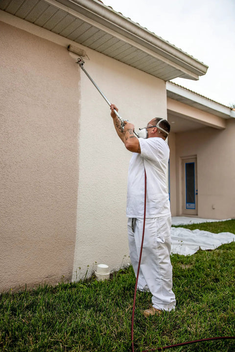 Pro Grade Spray And Roll Painting Kit With Three Foot Pole For Textured Walls in use on exterior wall for smooth finish.