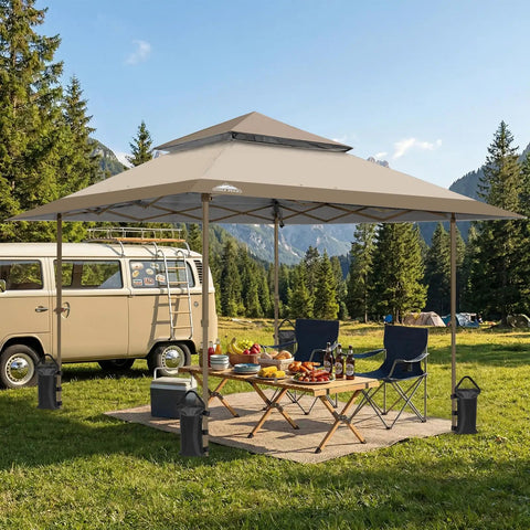 One Person Pop Up Canopy Tent With Instant Setup And Auto Extending Eaves 13 By 13 Foot Frame 169 Square Feet Of Shade Beige Folding Shelter For Tailgates Camping Picnics Beach Or Outdoor Events in a grassy field with chairs and table.