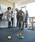 Office setting with golfer using Precision Reader Levels Golf Marker And Putting Aid With Round Bubble Level To Read Greens.