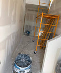 No Nonsense Heavy Duty Axial Air Mover Fan With Variable Speed Control And Three Hour Timer Pulling Maximum Cubic Feet Per Minute Through Wet Basement Spaces Blue positioned in unfinished hallway next to scaffolding.