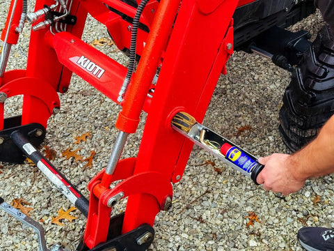 Person installing Space Saving Hidden Torque Tube Tool Tray Organizer for Front End Loader Tractor onto loader tubes.
