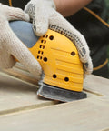 Worker using Triangle Sanding Pads Set For 3-1/8 Inch Oscillating Multi Tools, 100 Pcs, Hook And Loop, on wood surface for smooth finish.