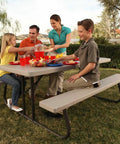 Family enjoying outside meal at 6-Foot Folding Picnic Table for Backyard Use With Eight-Seat Capacity, UV Protected HDPE Top, Powder Coated Steel Frame