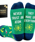 Funny Nerdy Socks For Men And Women Science Teacher Stocking Stuffers Pharmacist Gift Chemistry Physics Neuroscience Humor Geeky Christmas Socks Gift For Scientists And Medical Pros with atom design and text "Never Trust an Atom They Make Up Everything" on green socks.