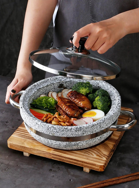 Korean Stone Bowl With Induction Base And Glass Lid, filled with food, on wood base with tray for bibimbap, soups, and hot pot.