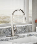 Top Shelf Pull Down Kitchen Sink Faucet With Smooth Glide Retractable Hose And Dual Function Sweep Sprayhead Built Tough For Lightning Fast Cleanup In Classic Vibrant Stainless Finish positioned on a granite countertop.