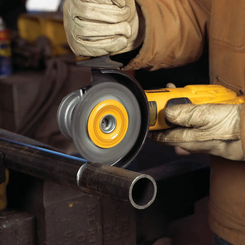 Person using heavy duty wire wheel brush for grinders, 4 inch diameter with 5/8-11 threaded arbor, on metal pipe