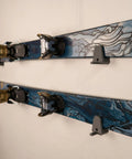 Slick Horizontal Ski Rack Wall Mount Bracket Black Hookless Design keeps skis flat against wall with blue topsheet pattern.