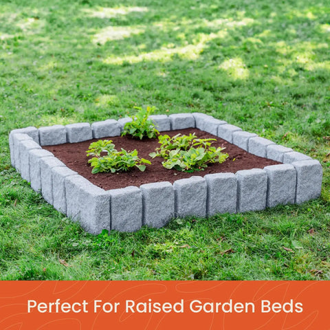 Landscape Edging Kit With Faux Stone Blocks XL For Lawn And Garden Borders Ten Pack Sixty Blocks Long Forty Eight Inches Wide Four Inches High Nine Point Five Inches Includes Thirty Spikes In Greystone surrounding a small garden bed.