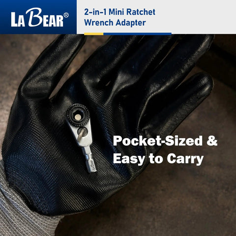 Gloved hand holding 2-In-1 Mini Ratchet Wrench Adapter With Magnetic One Quarter Inch Hex Bit Holder And One Quarter Inch Drive Socket Adapter, Compact Pocket Sized screwdriver and socket accessory.