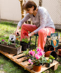 Woman gardening on Garden Kneeler And Seat Foldable Bench With EVA Foam Pad And Tool Pouch Outdoor Portable Stool Built To Handle 330 Lbs