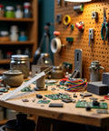 Electronics workbench cluttered with circuit boards, wires, and pliers on a pegboard wall