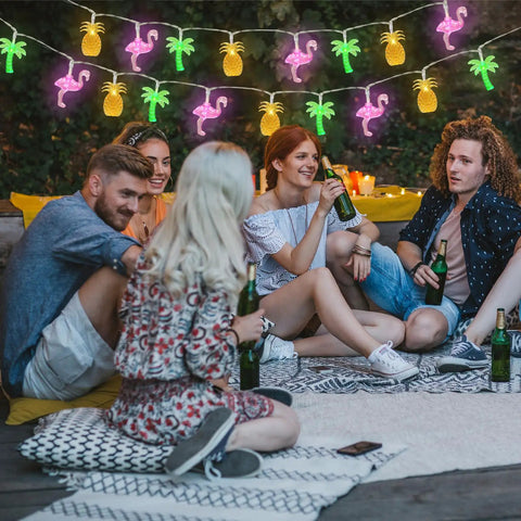 Tropical Flamingo Pineapple Palm Tree LED String Lights, 30 LEDs, 16 Ft Battery Operated hanging in a patio setting during a party