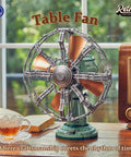 Retro Buildable Desk Fan Model For Adults Dope Green Display Piece With Motorized Oscillation Realistic Grille Weighted Base Bronze Blades Vintage Inspired Decor on a wooden desk with a teacup.
