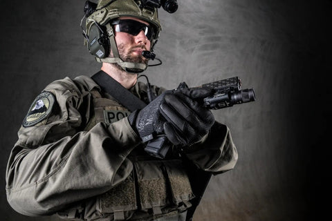 Person in tactical gear wearing black 0.5mm AX-Suede Tactical Gloves With Tight Fit And Precision Feel For High Dexterity In Airsoft.