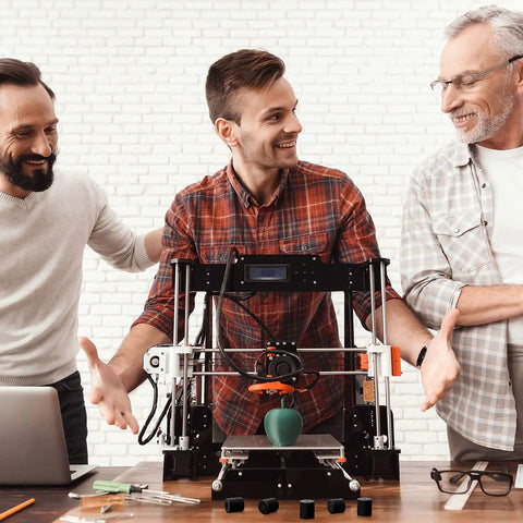 Smiling men discussing 3D printer with silicone heatbed leveling parts for CR-10, Ender 3, sizes 0.63 inch, 0.7 inch, black.