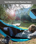 Person reclining in Camping Hammock With Built In Mosquito Net And Rain Fly, Heavy Duty Tree Straps, Nylon Parachute Fabric