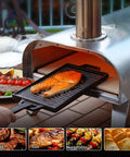 A person using a 12-Inch Multi-Fuel Outdoor Pizza Oven for Backyard Cooking, grilling fish on a cast iron pan.