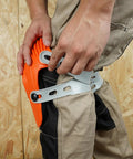Person wearing Ultraflex Non-Skid Kneepads With Flexible Design, securing orange plastic gear for construction and DIY use
