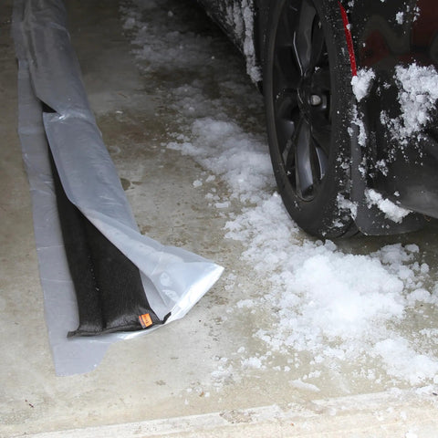 Water Activated Flood Barrier 5 Feet Pack Black in a garage blocking snow, no sand or labor needed, flexible design for flood control