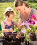 Child and adult planting flowers in clear 4 inch plant pots with drainage holes in garden, highlighting DIY seed starter use.