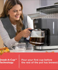 Woman using CafeCraft 12 Cup Programmable Coffee Maker With Stainless Steel Drip Design, visible Sneak A Cup feature