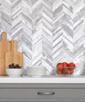 10 Sheet Herringbone Peel And Stick Backsplash In Vintage White Wood Look PVC for kitchen with cutting boards and fruit bowls.