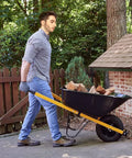 Man using a wheelbarrow fitted with Heavy Duty Wheelbarrow Axle Bracket Set For 5/8 Inch Axles With Bolt And Nut