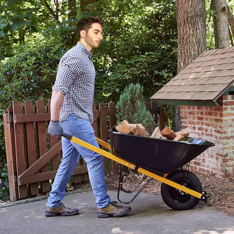 Man using a wheelbarrow fitted with Heavy Duty Wheelbarrow Axle Bracket Set For 5/8 Inch Axles With Bolt And Nut