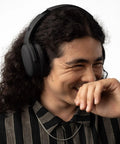 Man wearing Crusher ANC 2 Wireless Over Ear Headphones With Feel The Bass Multi Sensory Crusher Bass Tech, smiling