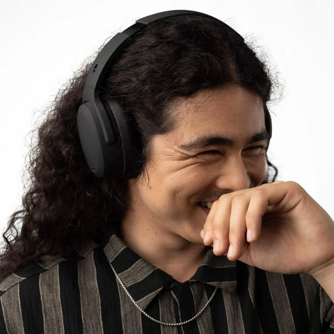 Man wearing Crusher ANC 2 Wireless Over Ear Headphones With Feel The Bass Multi Sensory Crusher Bass Tech, smiling
