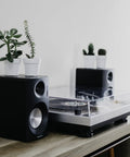 Crosley C100A Silver Belt Drive Turntable with Aluminum Tonearm on a wooden desk, compact design for vinyl records.