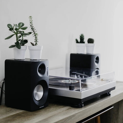 Crosley C100A Silver Belt Drive Turntable with Aluminum Tonearm on a wooden desk, compact design for vinyl records.