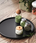 Real Deal Bamboo Lazy Susan Organizer For Kitchen Cabinet Super Slick Rotating Swivel Tray with jars of herbs on a black turntable.