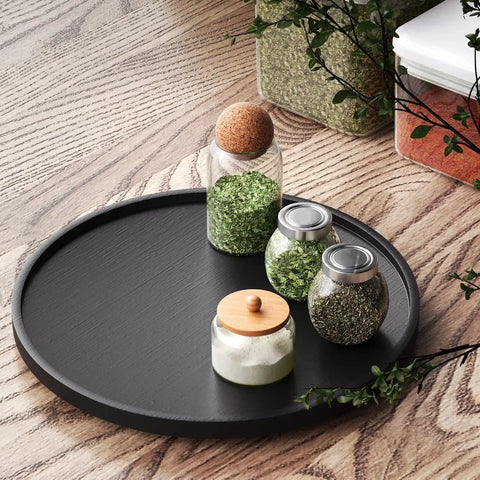 Real Deal Bamboo Lazy Susan Organizer For Kitchen Cabinet Super Slick Rotating Swivel Tray with jars of herbs on a black turntable.