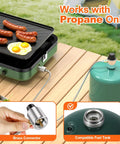 Two Burner Foldable Camping Stove With Carry Bag For Outdoor Cooking setup showing propane connection and eggs with sausages cooking.
