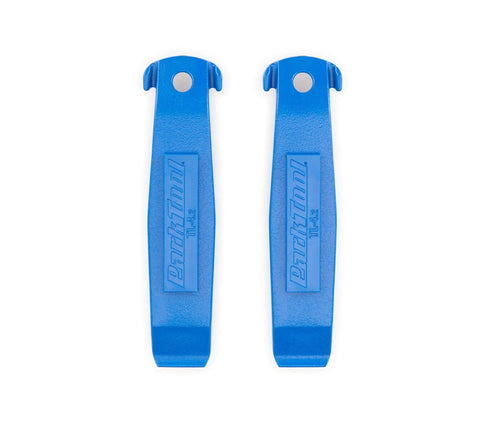 Two blue levers from Three Tire Levers Set With TL-1.2 Narrow Tip, TL-4.2 Ergonomic Wide Flat Tip, And TL-6.2 Ultra Strong Build for tire removal.