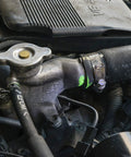 Automotive engine cooling system component: radiator hose, silver cap, and metal hose clamp