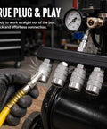 Top Shelf 4 Way Straight Air Manifold Splitter With Quarter Inch Quick Couplers Solid Aluminum Body And Heavy Duty Steel Fittings For Air Compressor Setup No Sweat Multi Tool Power Flow in use with yellow hose and tools.