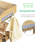 Close-up of strong metal hooks on outdoor garden potting bench with metal top storage shelf, part of fir wood workstation.