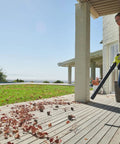 Person using the 18V One Plus Brushless Compact Blower Bare Tool With Variable Speed Trigger And Lock On for yard cleanup on a deck