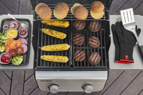 Propane Grill For Outdoor Cooking And BBQ With 2 Burners Black Finish Porcelain-Enameled Cast Iron Grates And Snap-Jet Ignition Ready To Grill Like A Pro grilling burgers and corn with buns on the warming rack