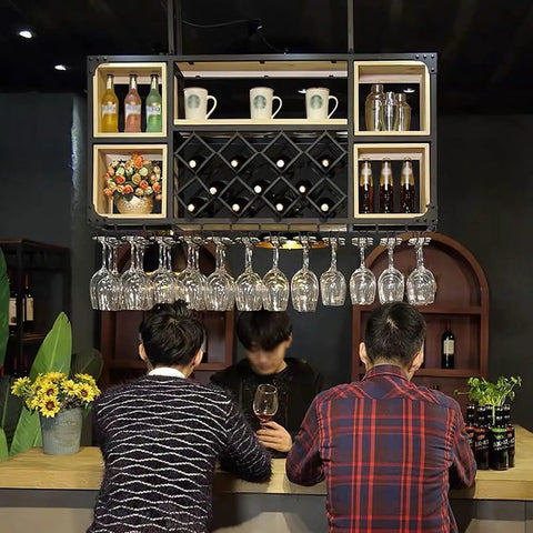 Industrial Iron And Raw Wood Wall Mounted Wine Rack featured above bar with wine bottles, glasses, and mugs hanging.