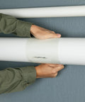 Hands applying Ultra Strong Waterproof Tape That Seals Leaks On Wet Surfaces And Underwater, Clear 8 Inch By 25 Foot Roll on pipe