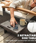 Woman using retractable side table on Rattan Outdoor Daybed With Storage Ottoman And Four In One Functionality Adjustable Backrest In Four Positions Folding Side Trays Acacia Wood Armrests Double Sun Lounger With Cushions And Pillows Beige.