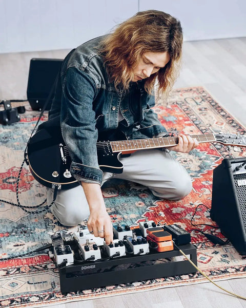 Musician setting up guitar on pedalboard case with Ultra Lightweight Aluminum Guitar Pedalboard Case 20x11.4x4 Inches.