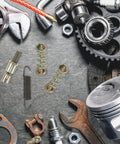 Heavy Duty Brake Adjustment Tool Kit With Metal Hold Down Springs And Pins For Drum Brakes In Construction Machinery, Beefed Up Friction Stability, Quick Spring Tool For Fast Stops, And Easier Loader Disc Brake Access. Metal brake springs and pins laid out on gray mat.