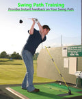 Man practicing golf swing with alignment sticks on driving range mat