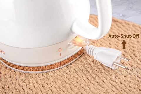 Close-up of Electric Ceramic Tea Kettle With 1 Liter Capacity showing auto shut off feature and power cord on a woven base.